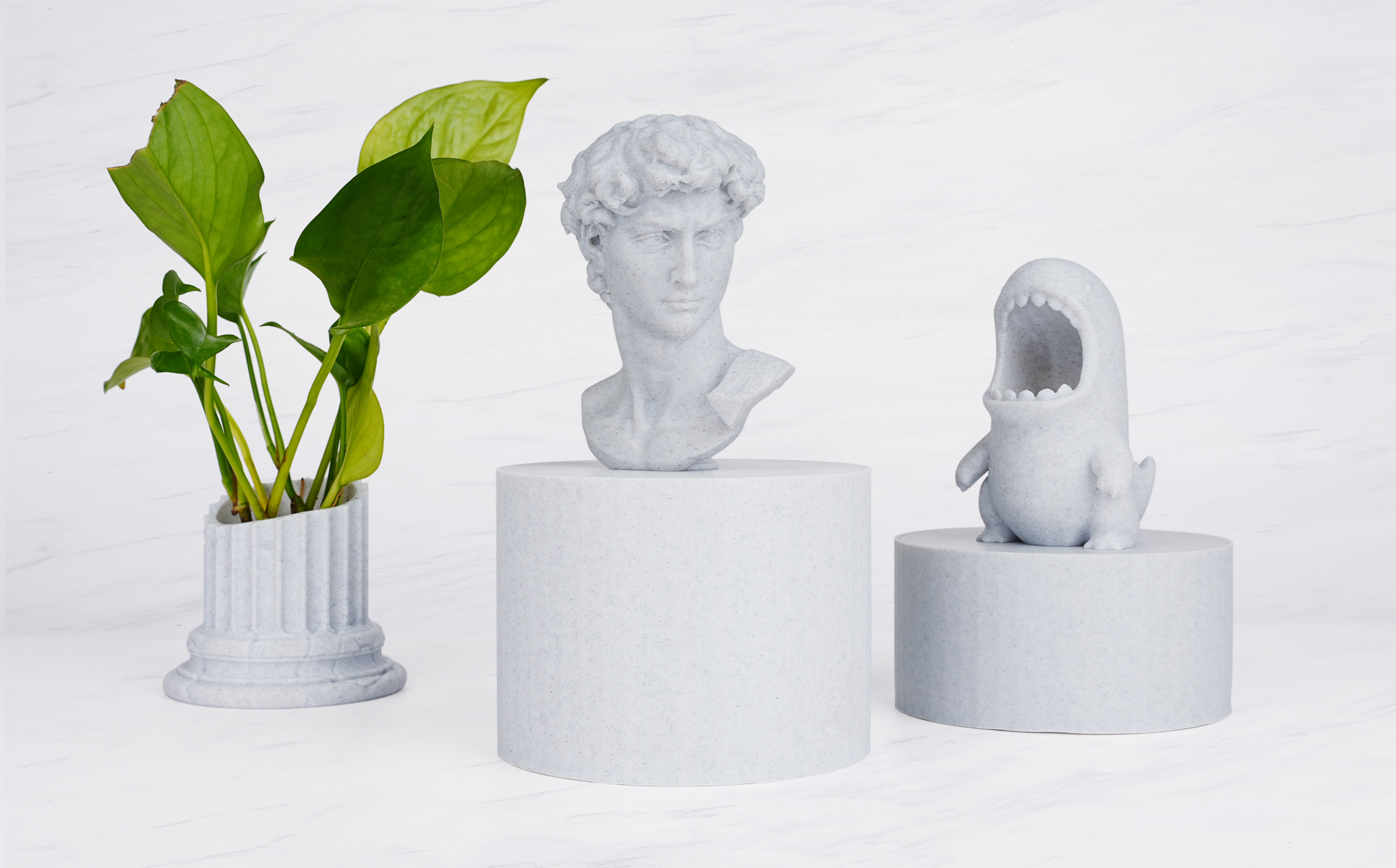 Galería de piezas impresas con PLA Mármol, incluyendo bustos clásicos y modelos arquitectónicos, resaltando su apariencia de escultura de piedra real.