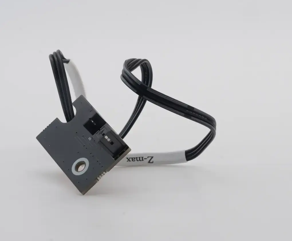 Vista trasera de la pequeña placa del sensor del eje Z, detallando los puntos de soldadura limpios y los orificios para los tornillos de anclaje